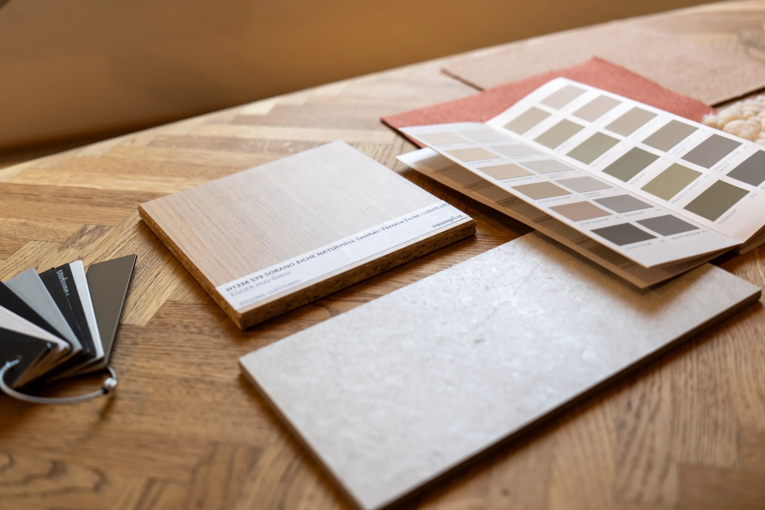 Ein Tisch auf dem verschiedene Materialproben und Farbfächer liegen