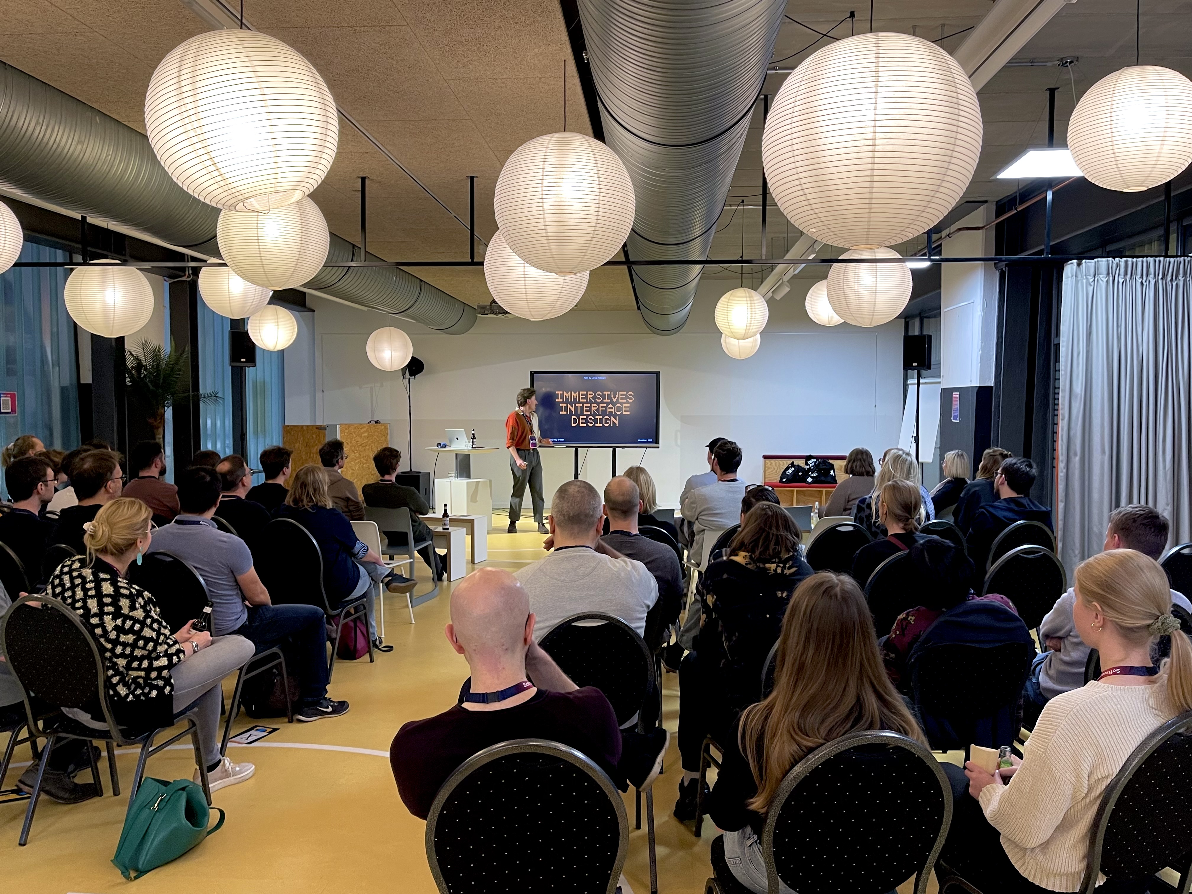 Viele Leute sitzen in einem Raum und hören Jonas bei seinem Vortrag zu